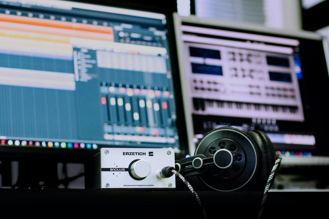 Headphones and headphone amplifier depicted in a mastering studio