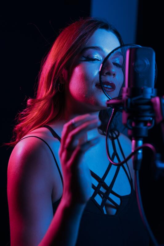 Picture of a woman recording a song in the hopes of winning free mastering